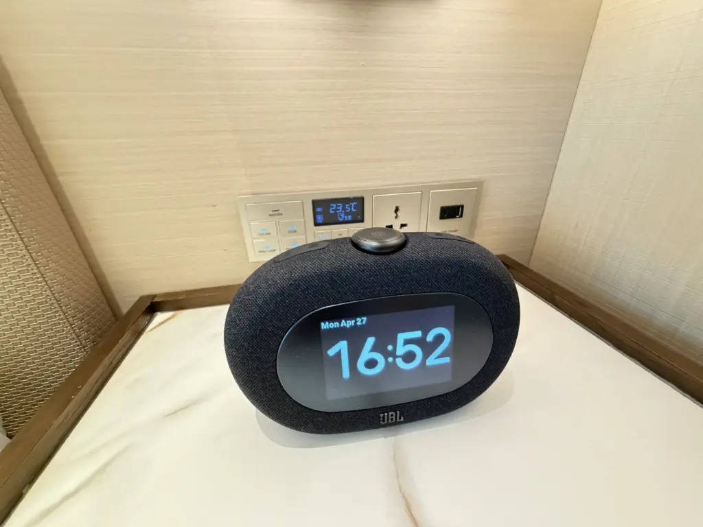 An alarm clock and power options on the right hand side of the bed An alarm clock and power options on the right hand side of the bed
