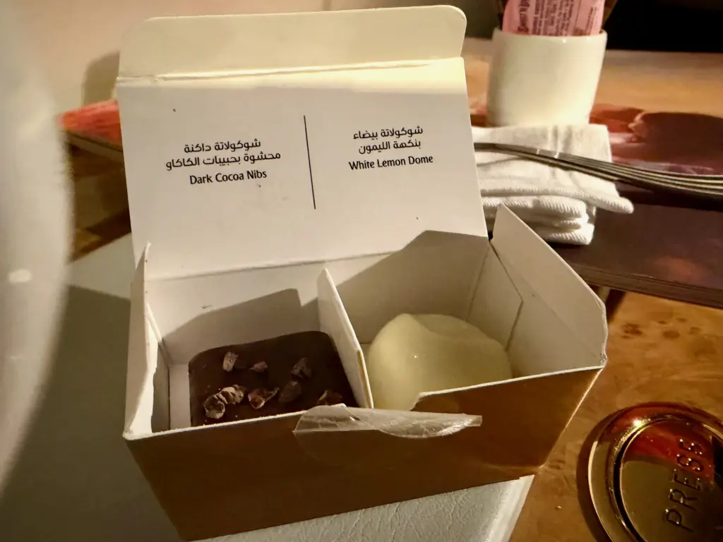 A small box of chocolates at my seat when I got back from my shower A photograph of a small chocolate box in Emirates First