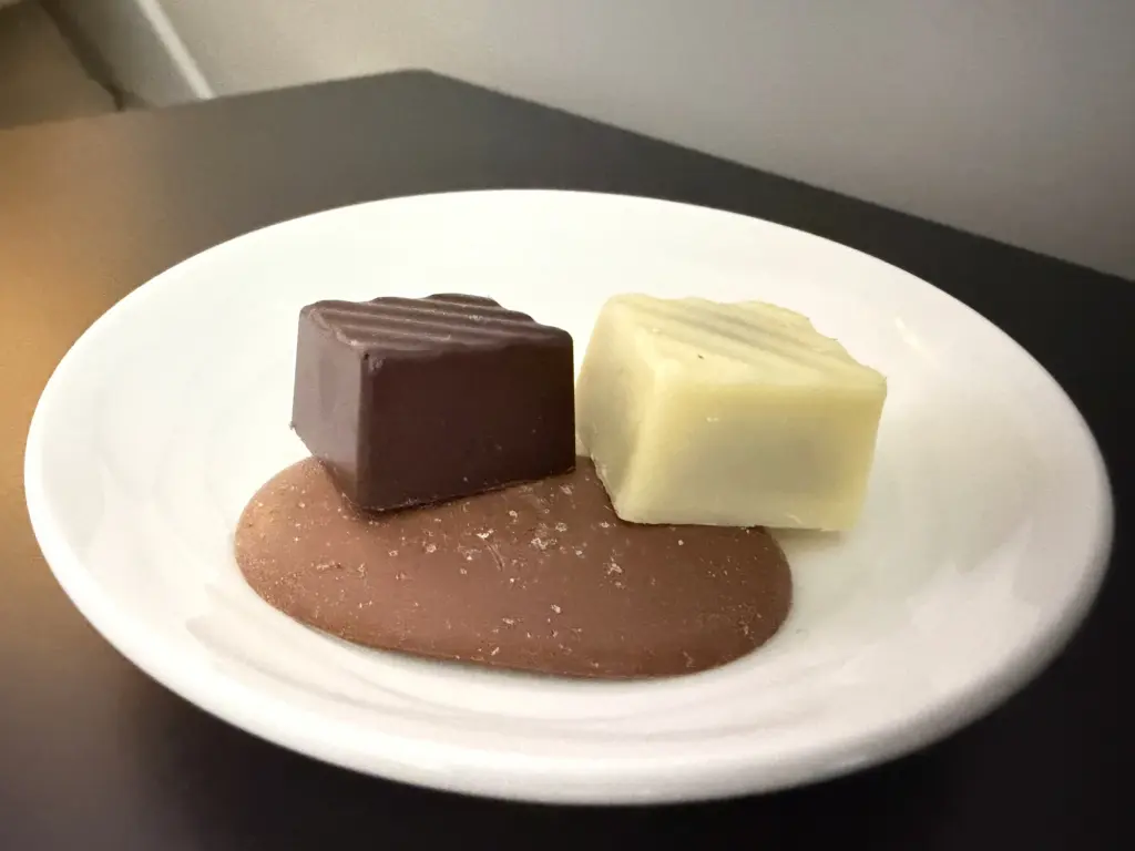 A snack before landing A photograph of three chocolates, offered as a snack in Emirates First