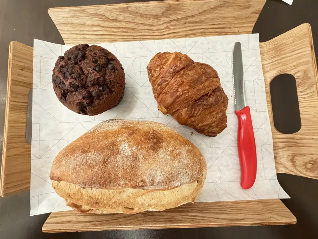 My pre flight snack at a Gimpo bakery A photograph showing a croissant, muffin and bread roll in a Korean cafe