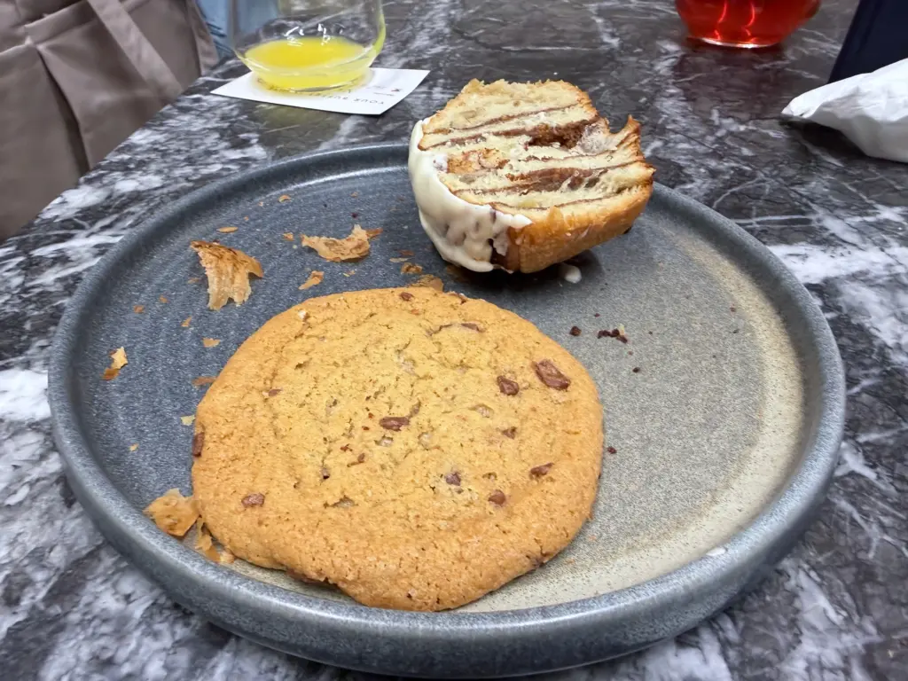 A photograph of a cookie and a cinnamon swirl