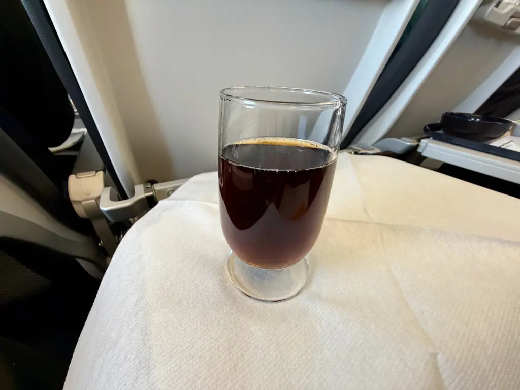 My coke served in a tiny glass A photograph of a small glass of diet coke on a Lufthansa A320